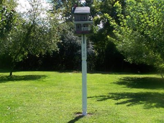 Birdhouse mounted on post in yard